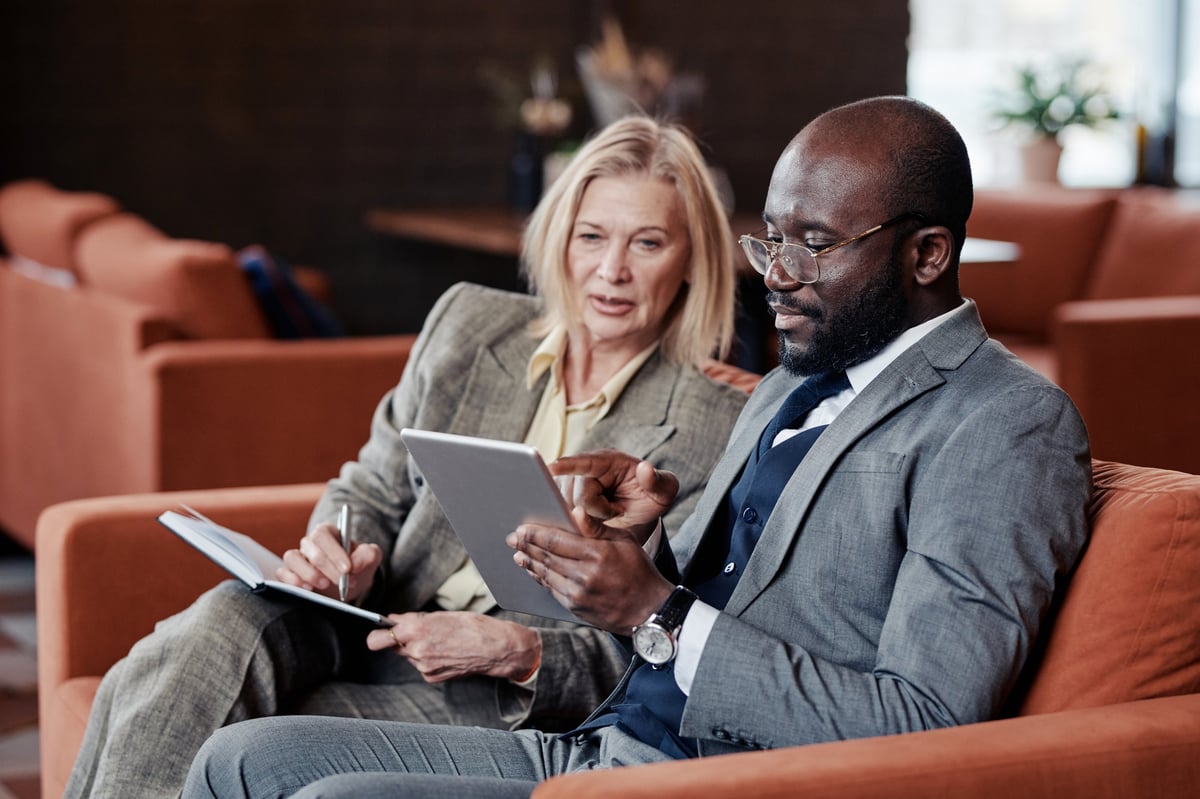 Two professionals planning work together over a tablet in a café