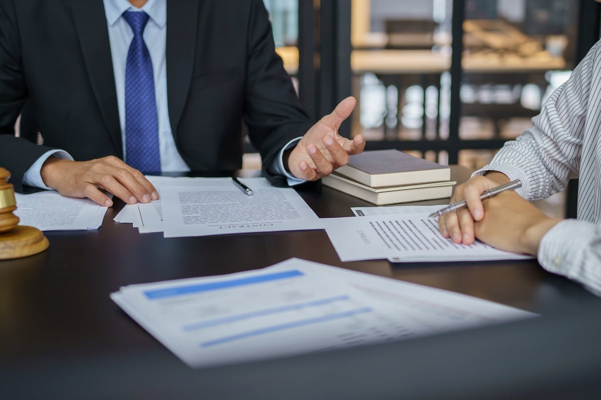 Advisor presenting a signed agreement to a client across a desk